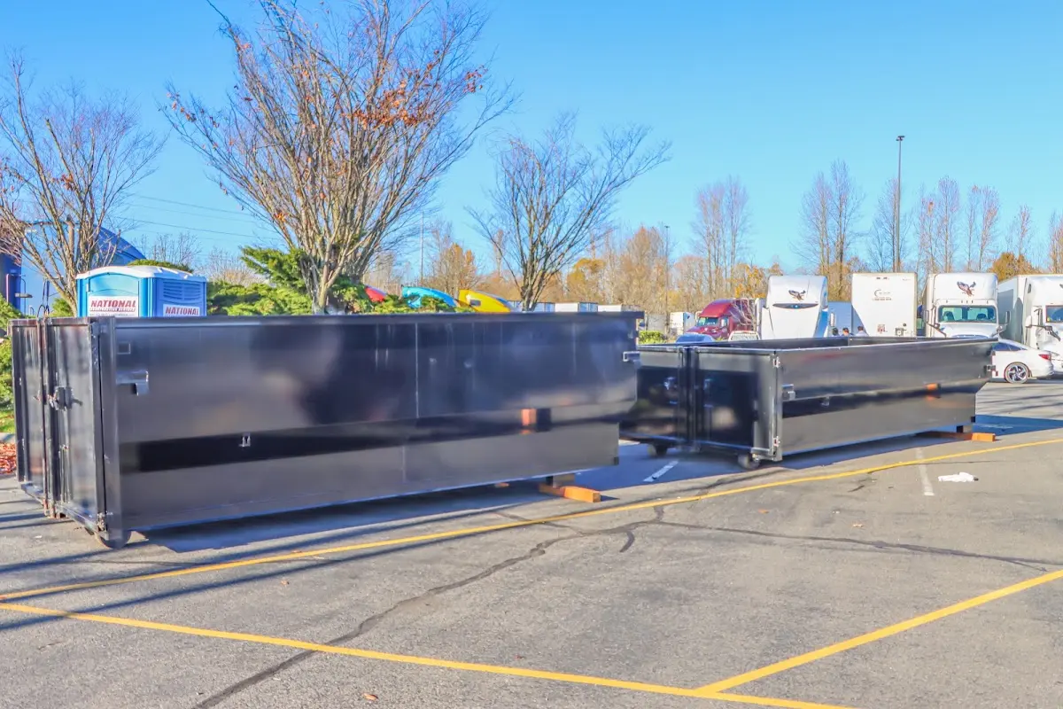 Professional dumpster rental service with roll-off container on residential driveway in Hilltown